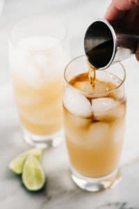 Dark and stormy drink vertical rum pouring small