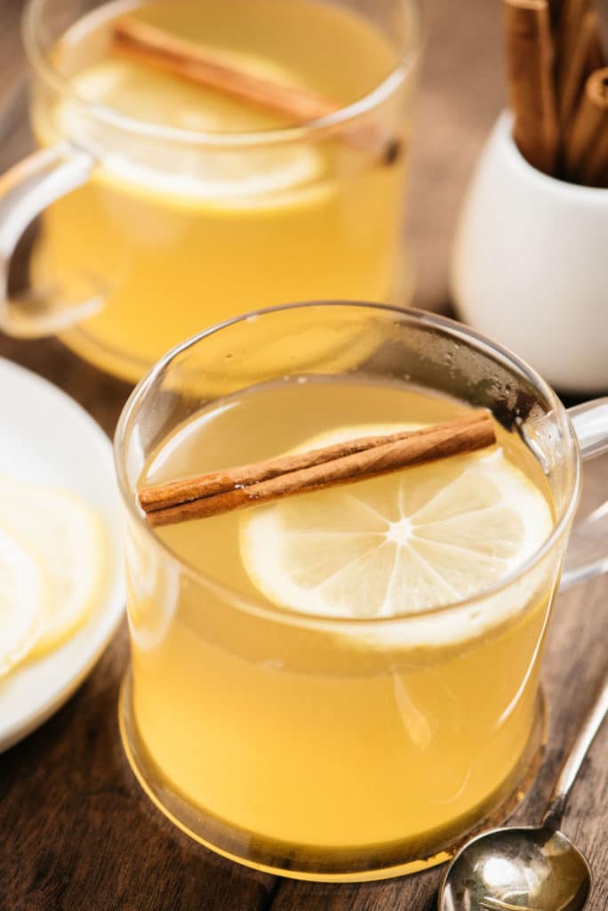 vertical hot toddy drink with lemon and cinnamon