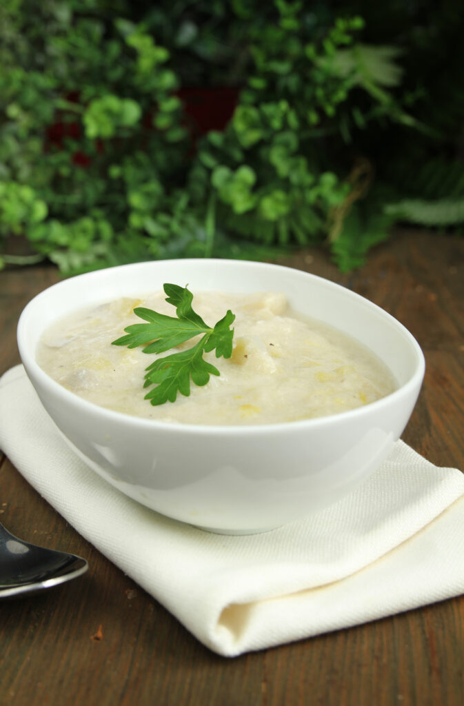 Vegan Leek and Potato Soup in white bowl vertical