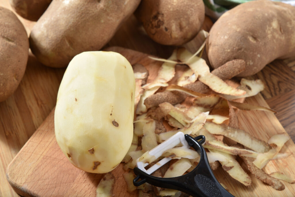 russet potatoes peeled on cutting board