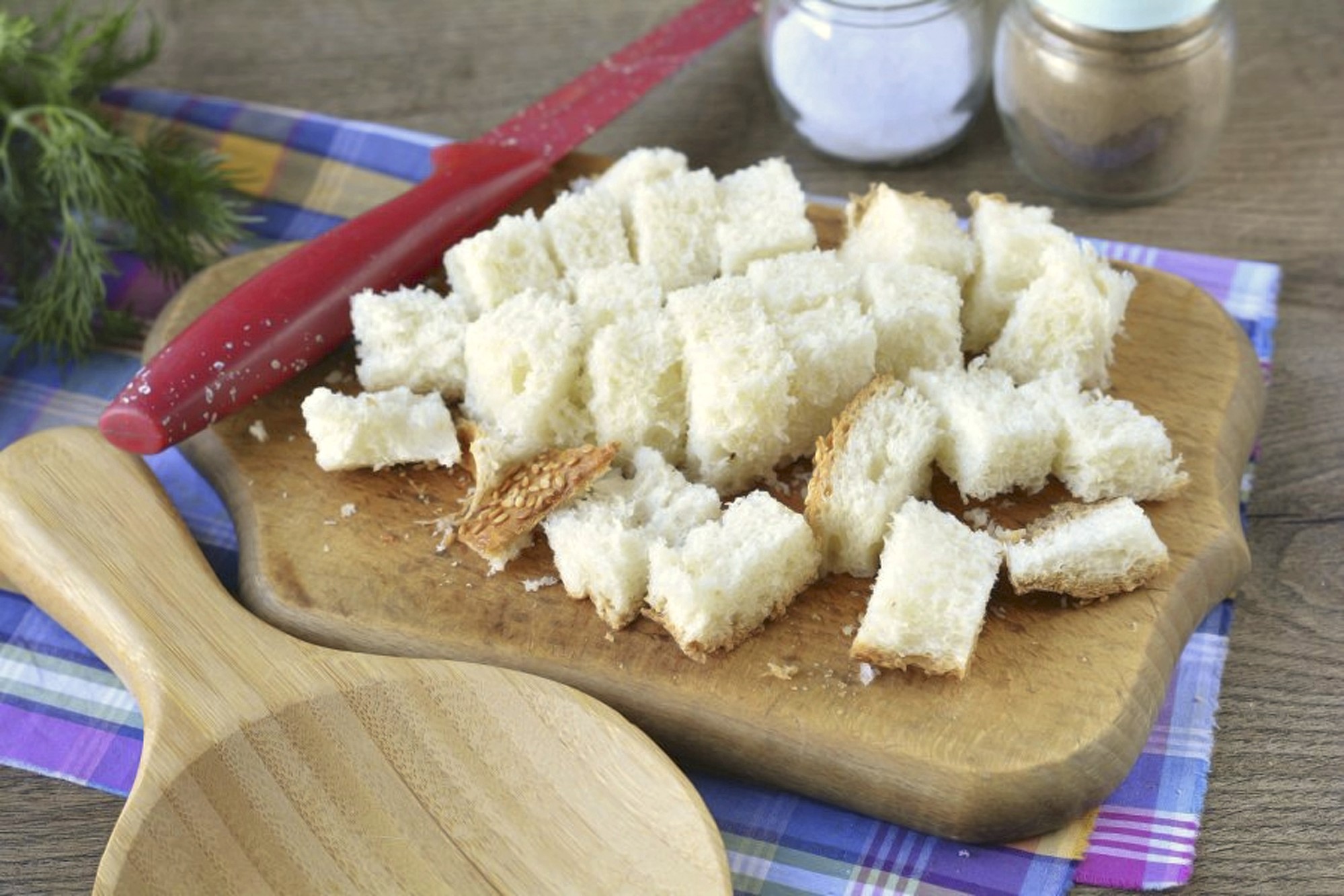 Cut the bread into cubes with a knife. The Spicy Apron