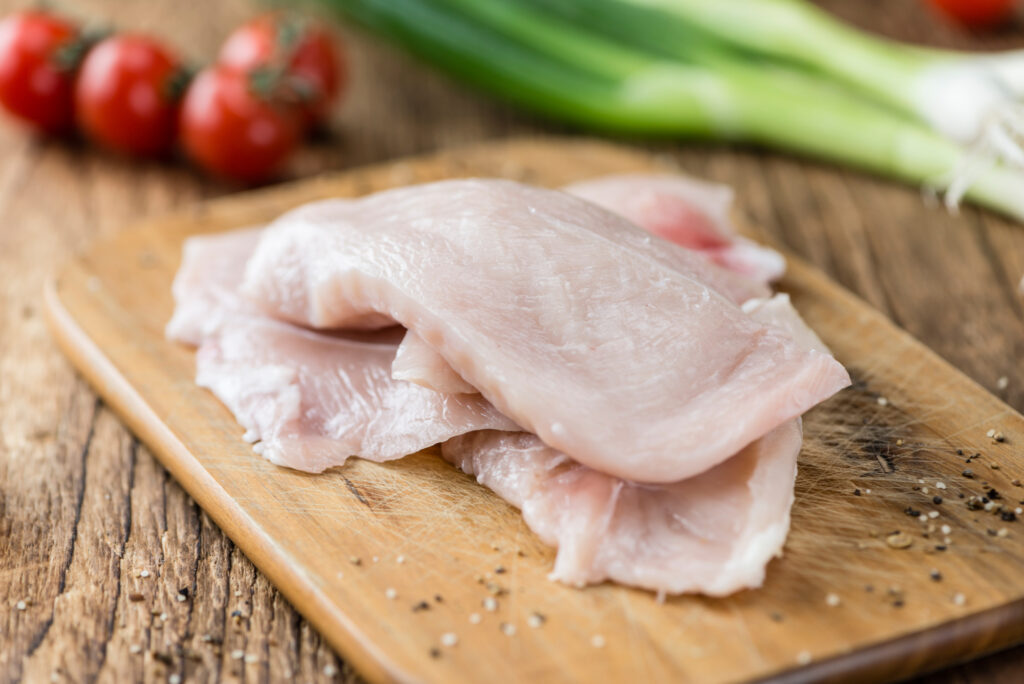 raw chicken cutlets on cutting board